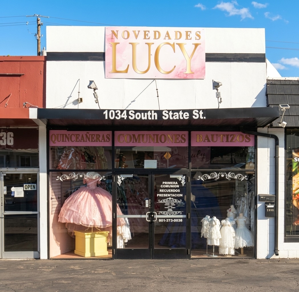 Novedades Lucy storefront at 1034 S State St in Orem, with window signs for Quinceañeras, Comuniones and Bautizos